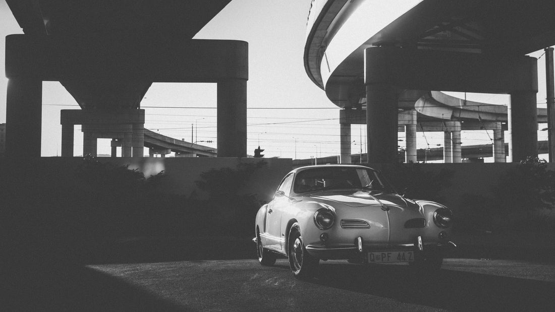 A 1961 Volkswagen Karmann Ghia beneath elevated roadways.