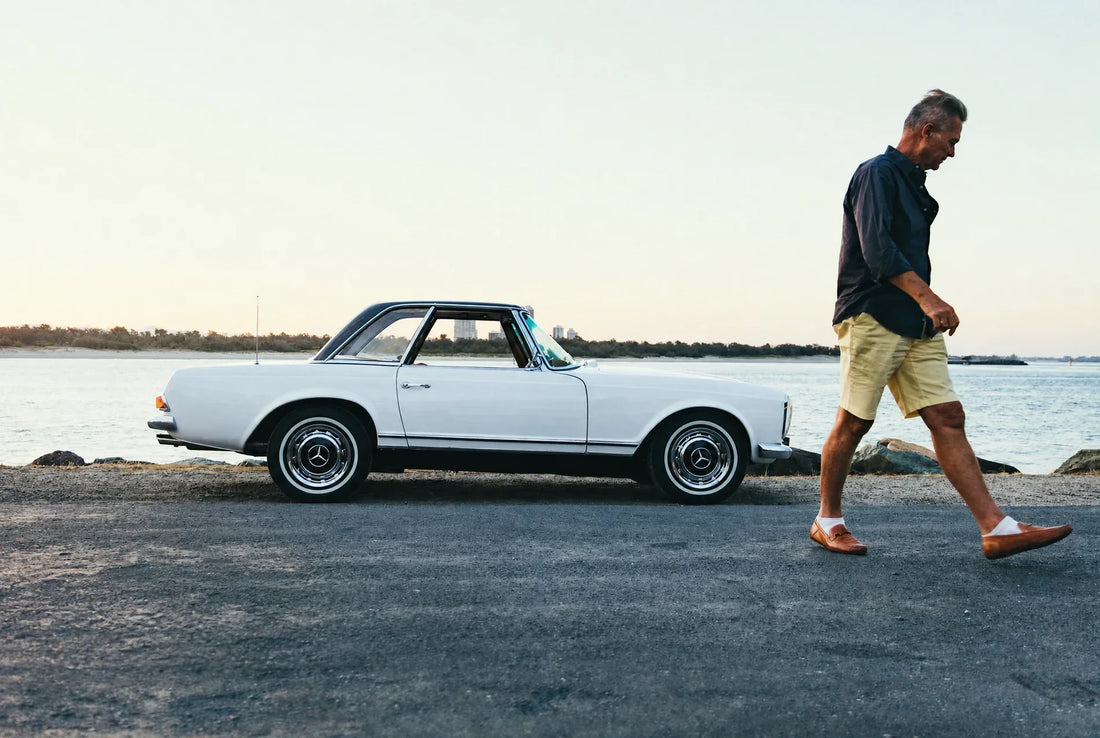 Paul Nelson walking beside his white 1964 Mercedes-Benz 230 SL.