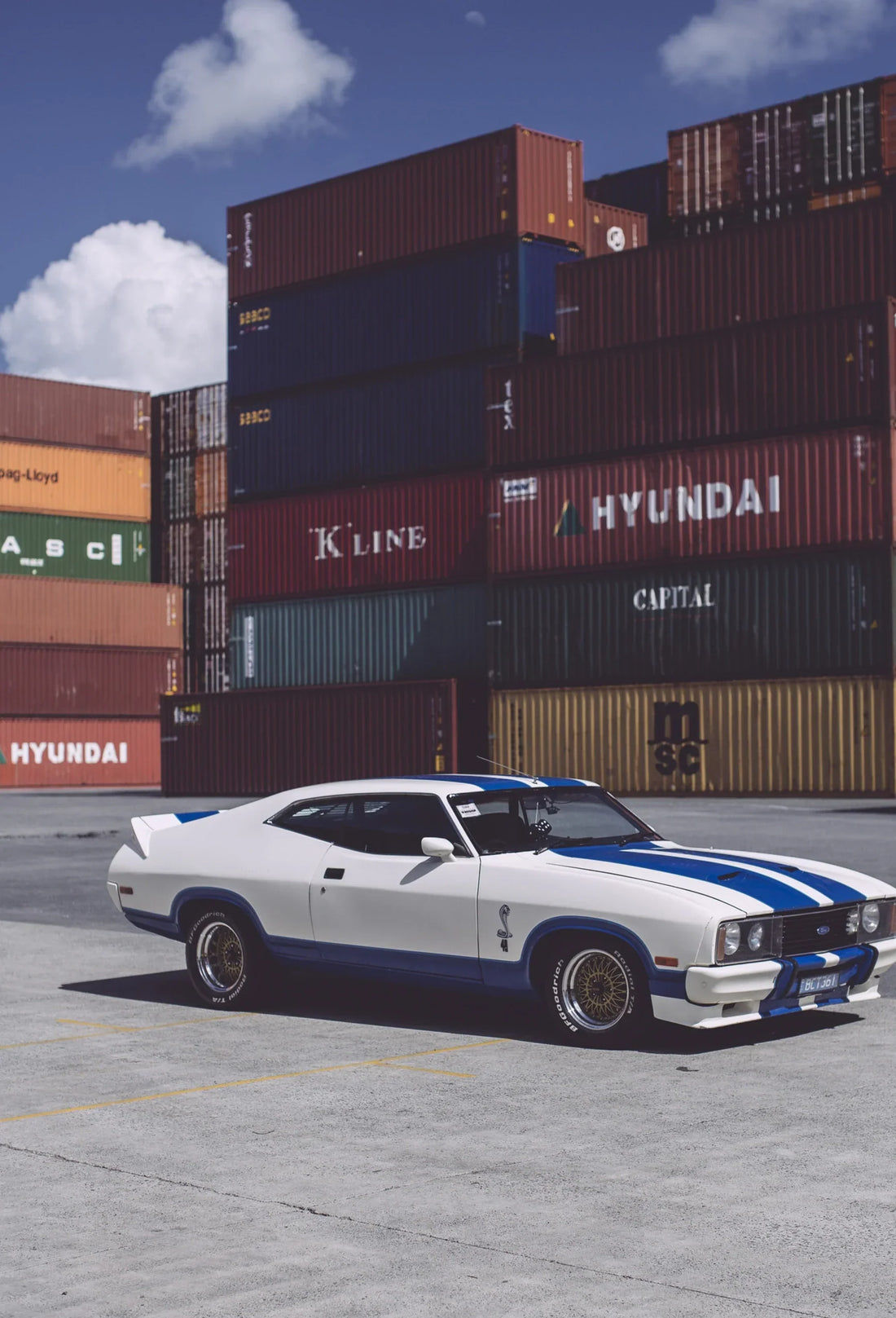 The Ford XC Cobra Hardtop in a shipping-container yard.