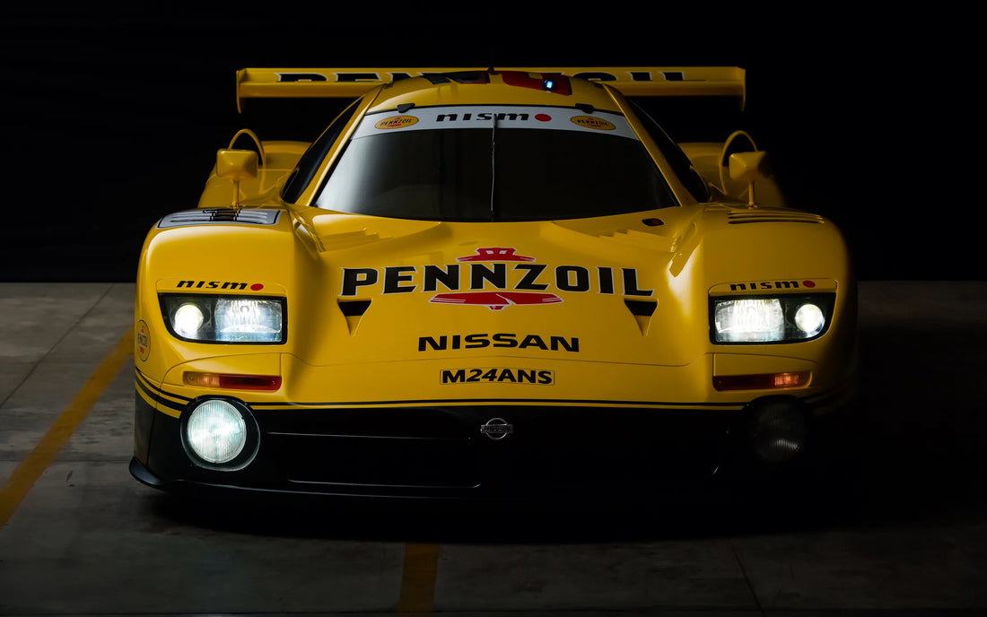 Yellow Nissan R390 GT1 photographed front-on against a dark background.